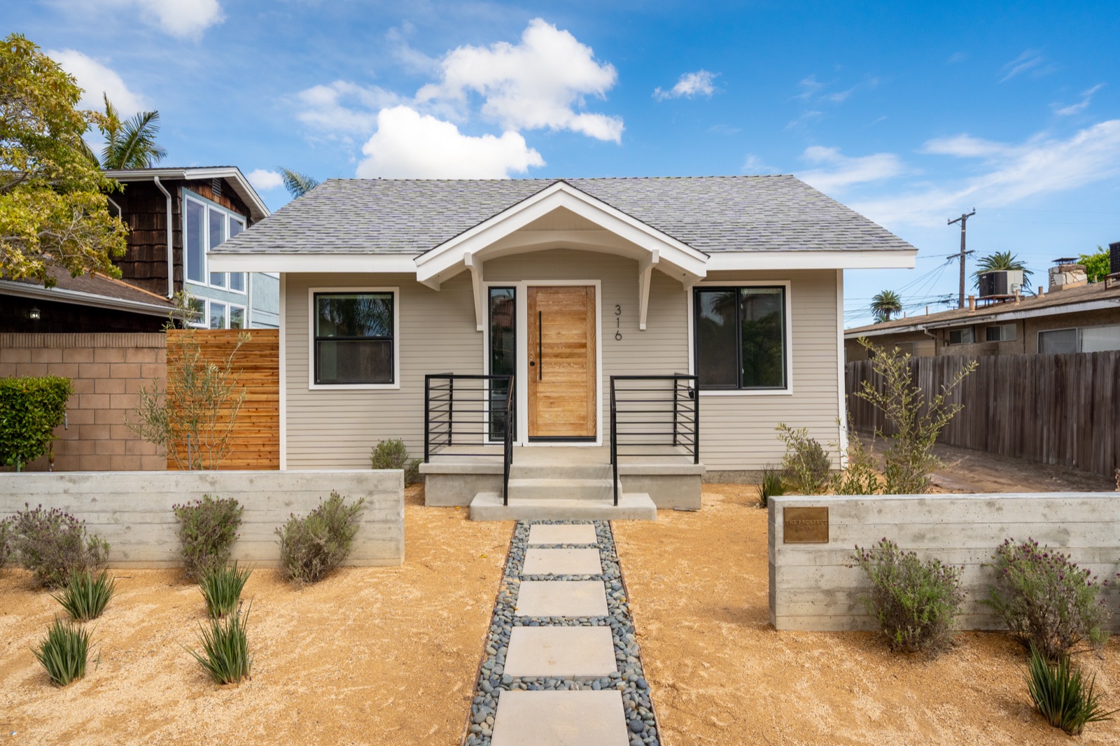 Daytime photo of a small craftsman bungalow, before editing
